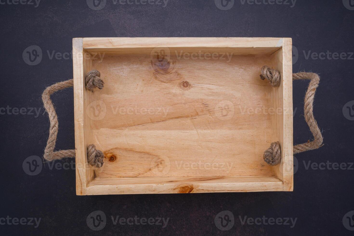 An empty wooden box is placed on dark stone background. Wood design. Space for text. Top view photo