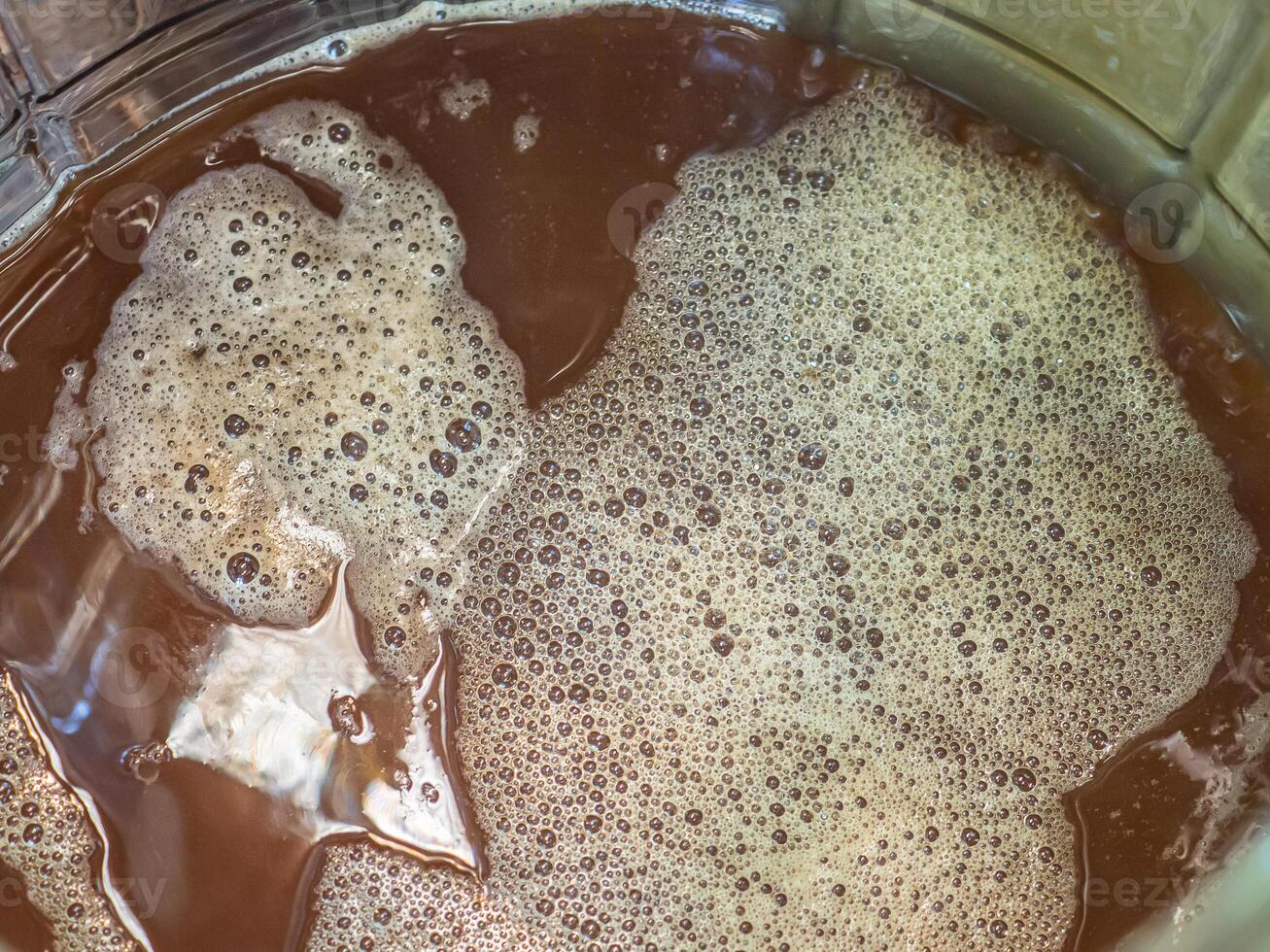 Close-up of craft beer and foam in a fermentation container. photo