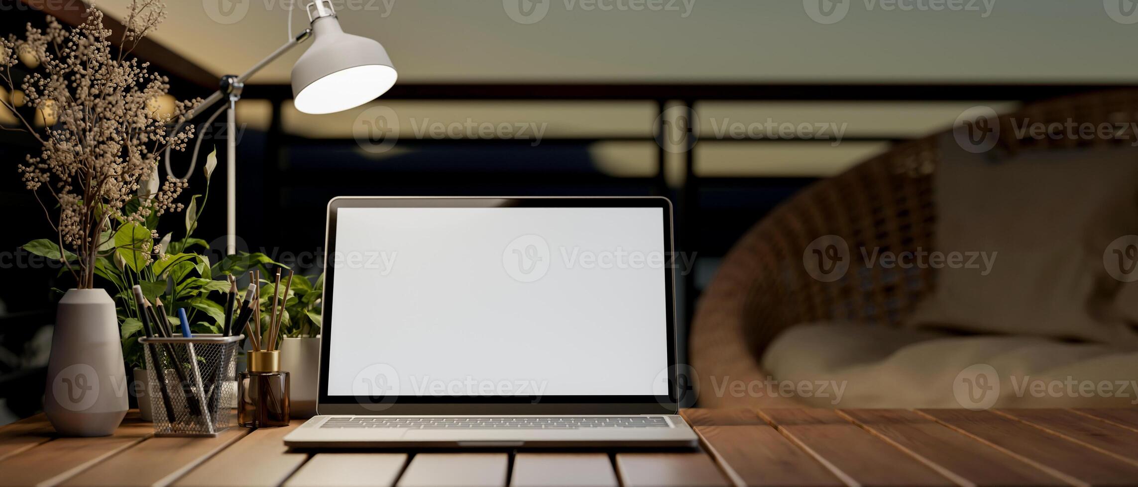 A laptop computer with a white-screen mockup on a wooden table on a balcony. photo