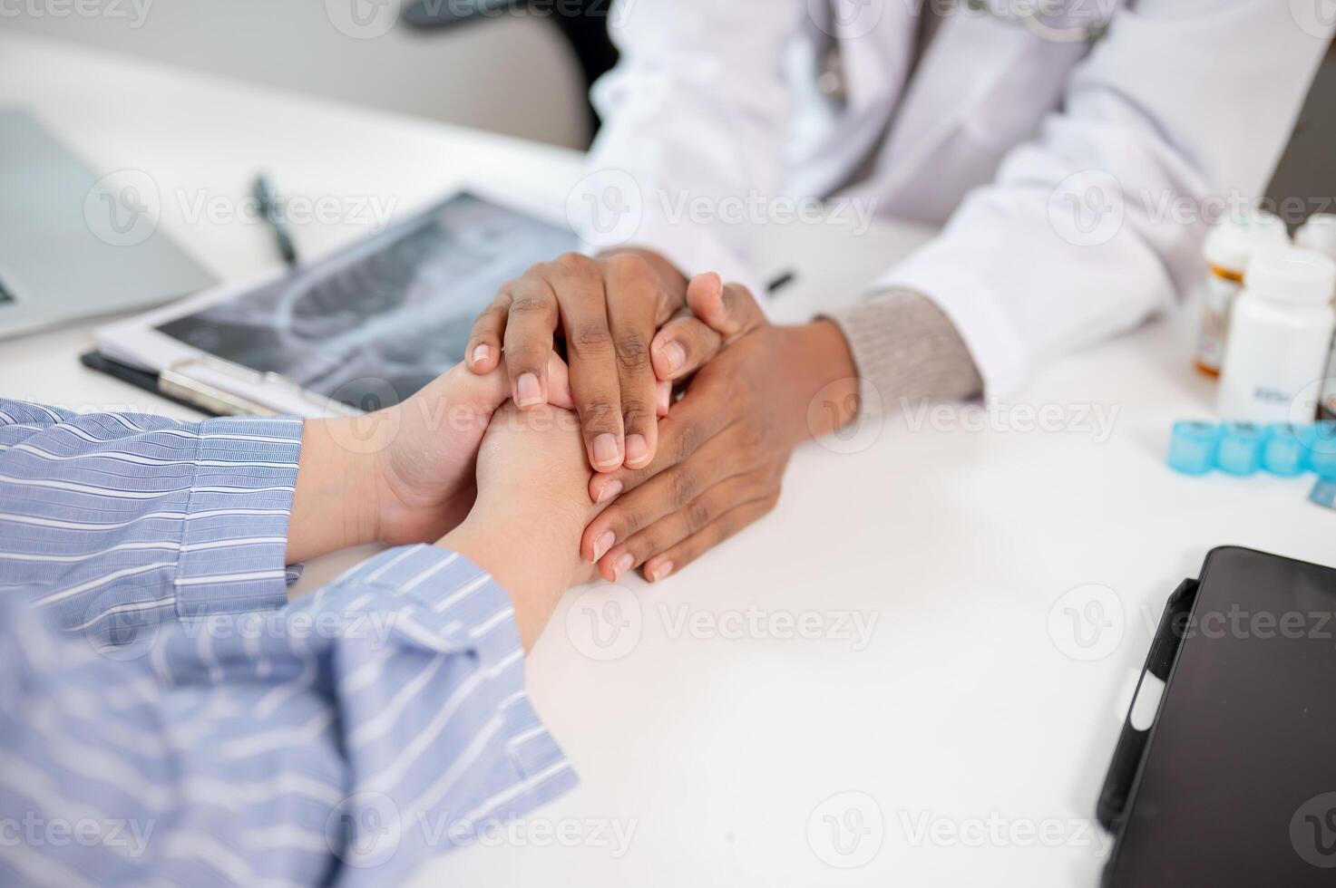 A close-up image of a caring female doctor holding a patient's hand to comfort and reassure them. photo