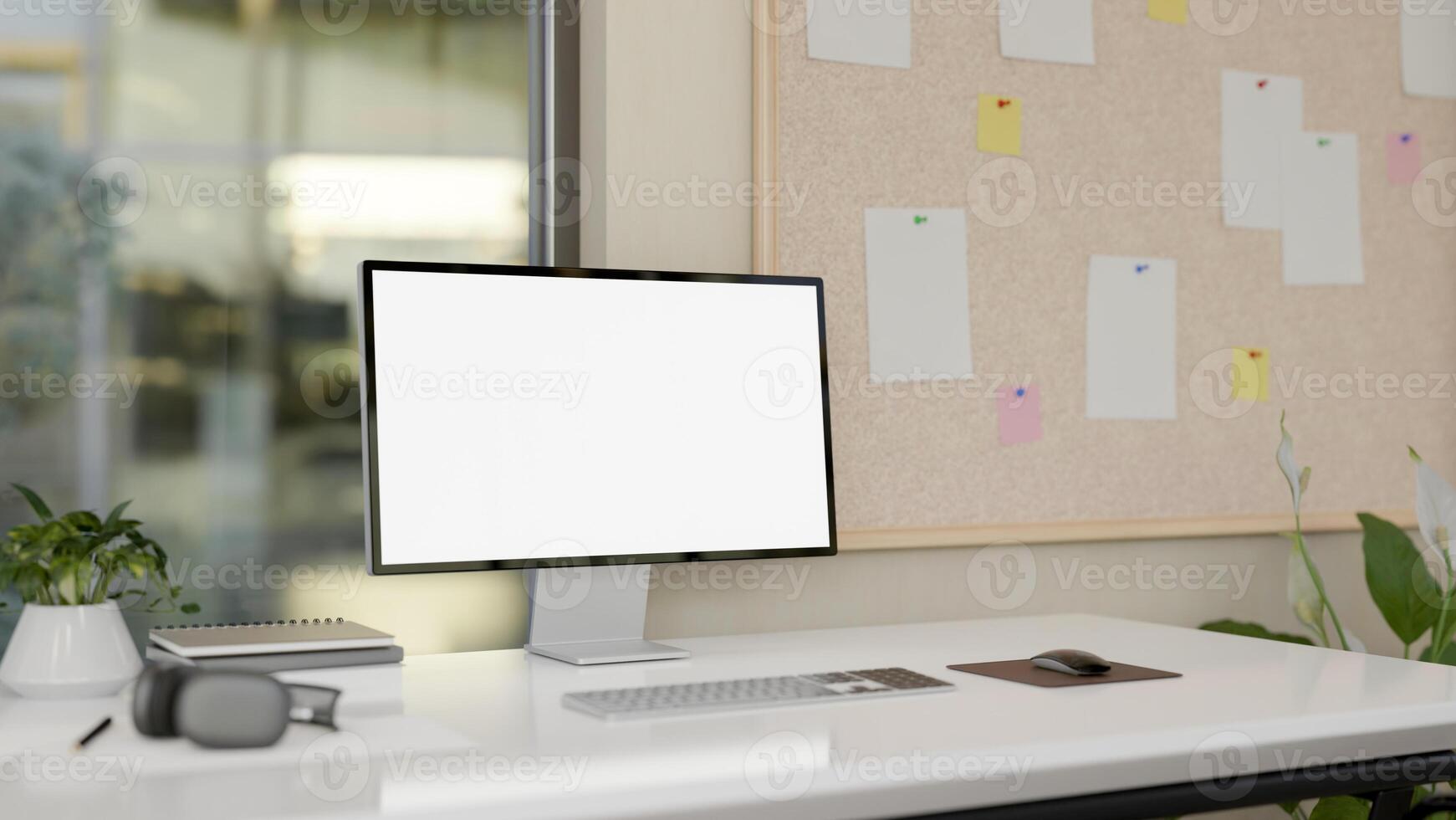 A computer desk in a modern office, a computer with a white-screen mockup on the desk. photo