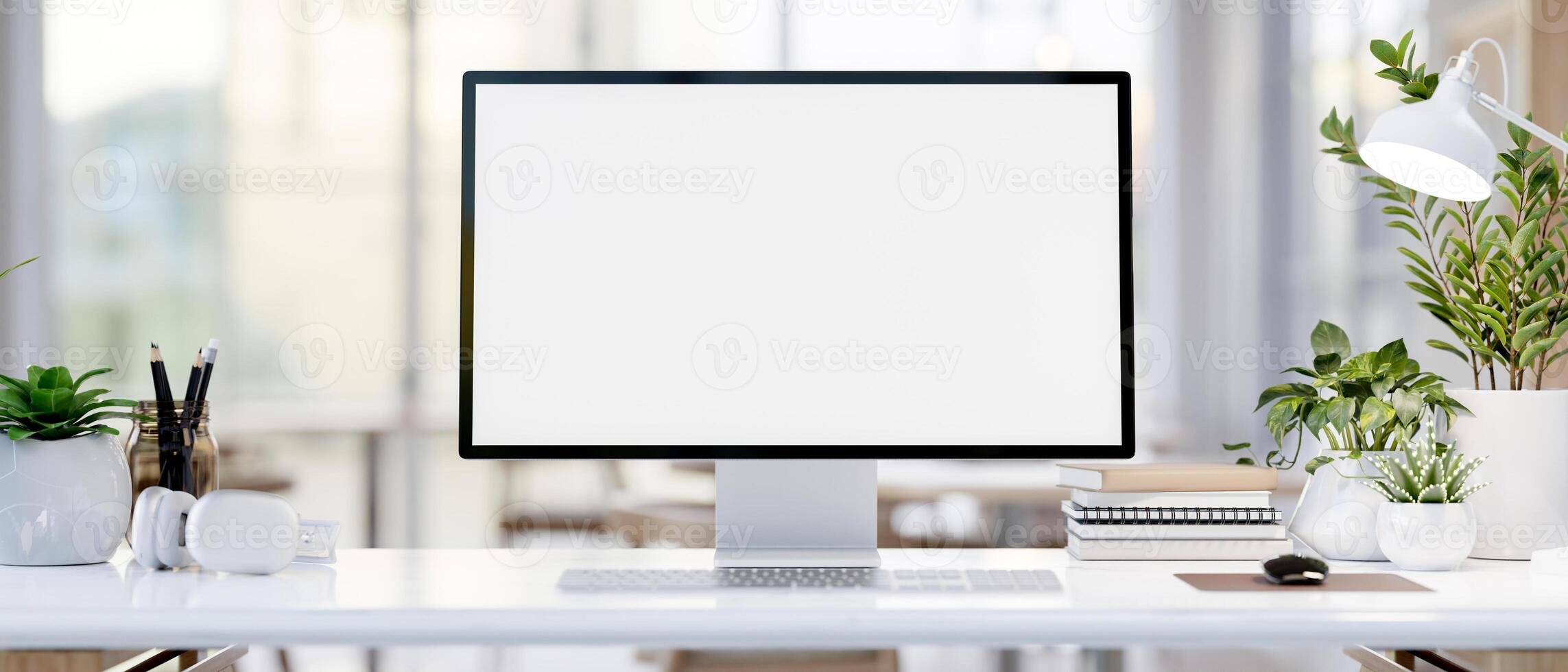 A computer desk featuring a computer mockup, books, headphones, and decorative plants. photo
