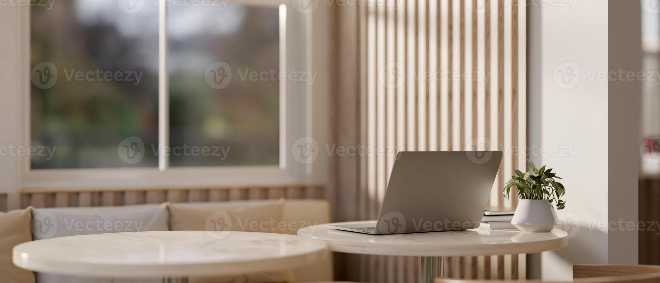 A back view image of a laptop computer on a table in a modern, comfortable cafe seating area. photo