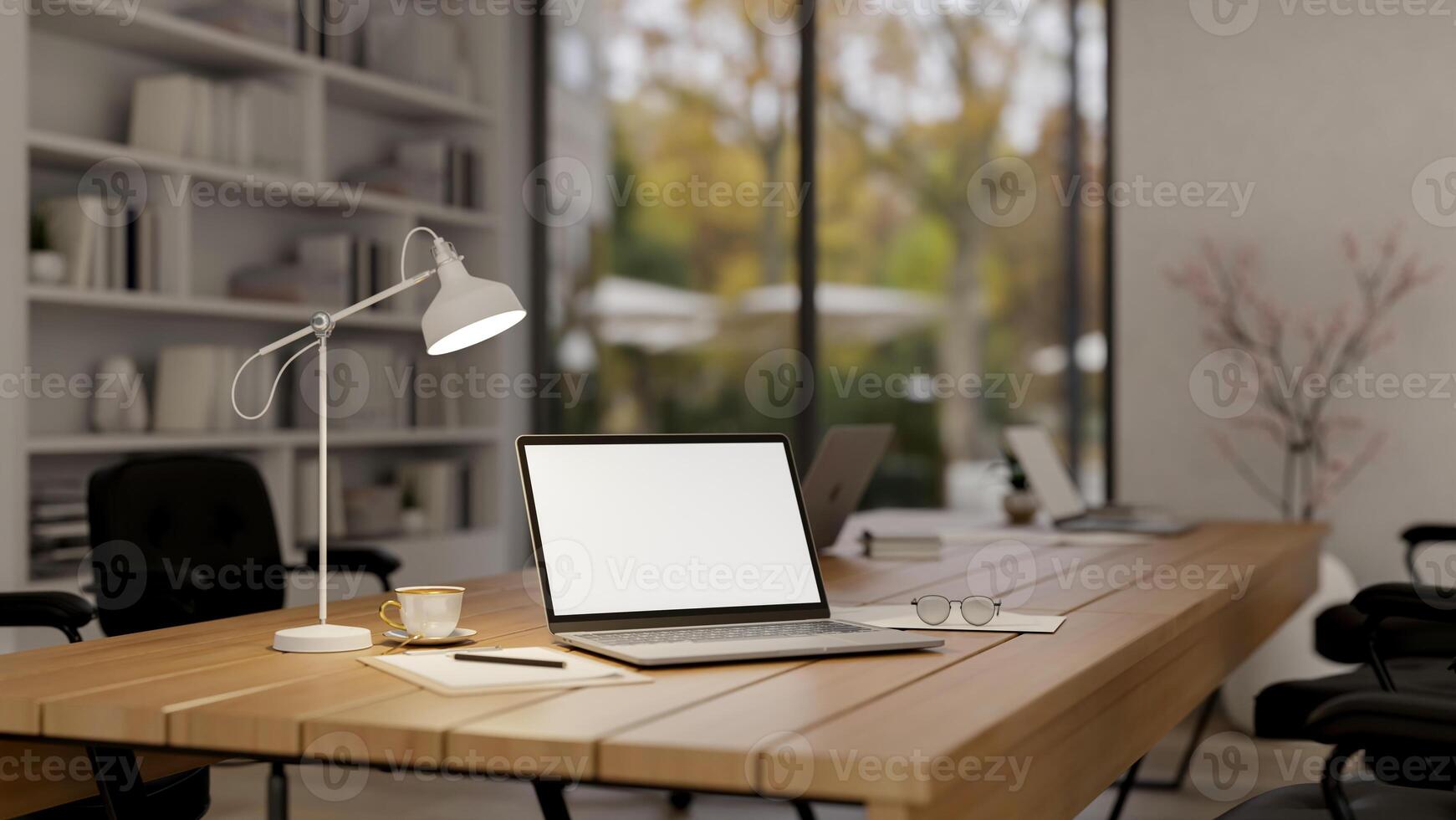 A laptop computer with a white-screen mockup on a wooden meeting table in a modern meeting room. photo