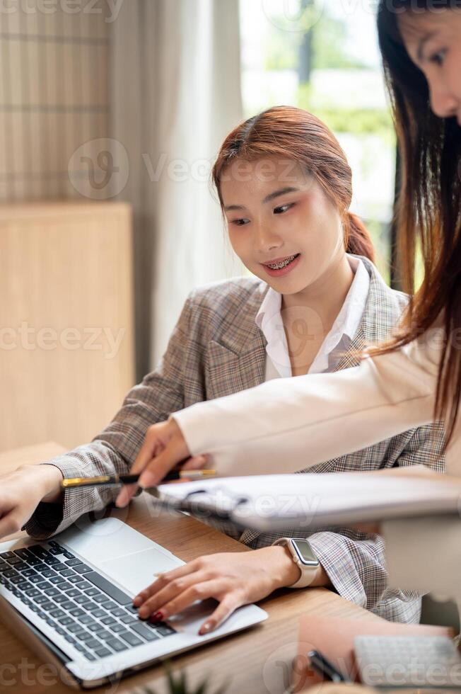 An Asian businesswoman is having a meeting with her colleague, discussing, planning their project. photo