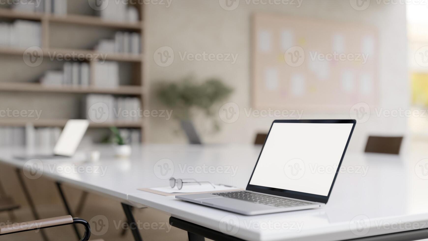 A laptop computer on a meeting table in a contemporary meeting room or office co-working space. photo