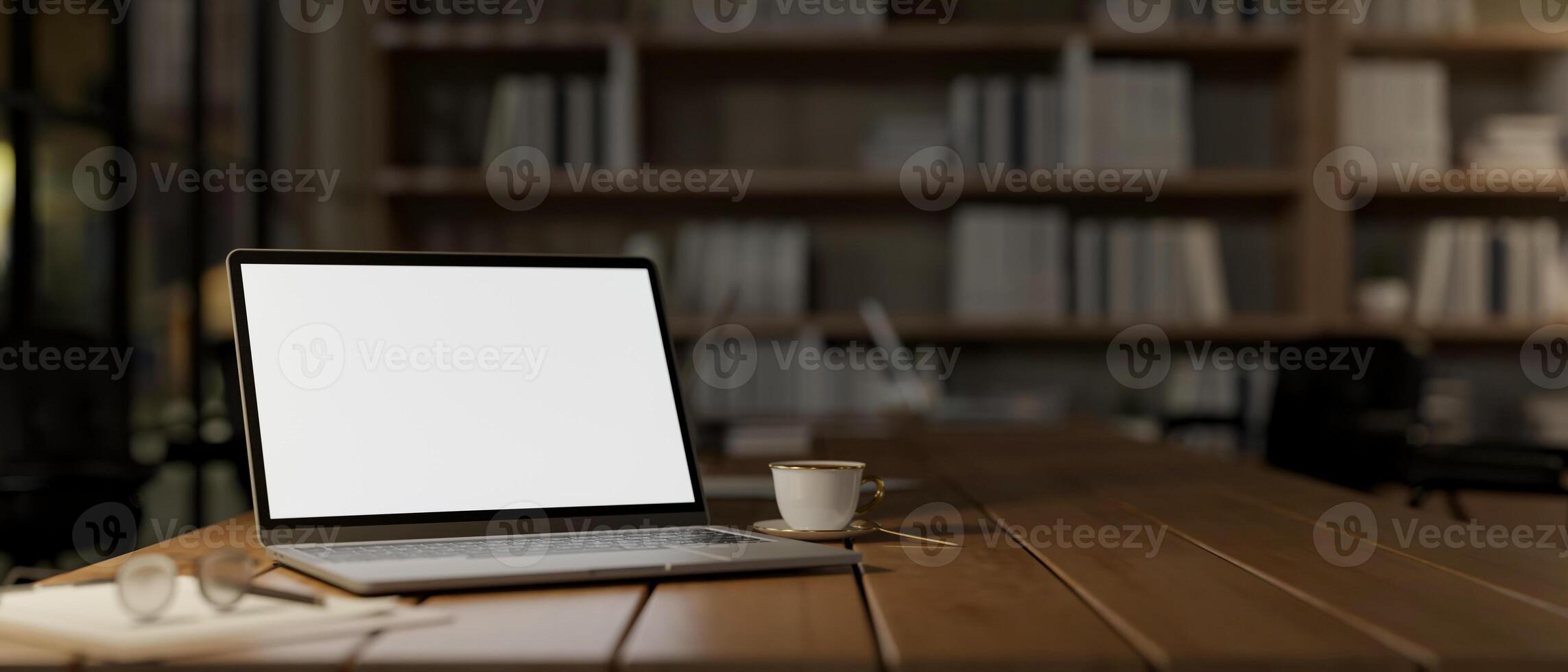 A close-up image of a laptop mockup on a wooden table in a cozy reading library room or home office. photo