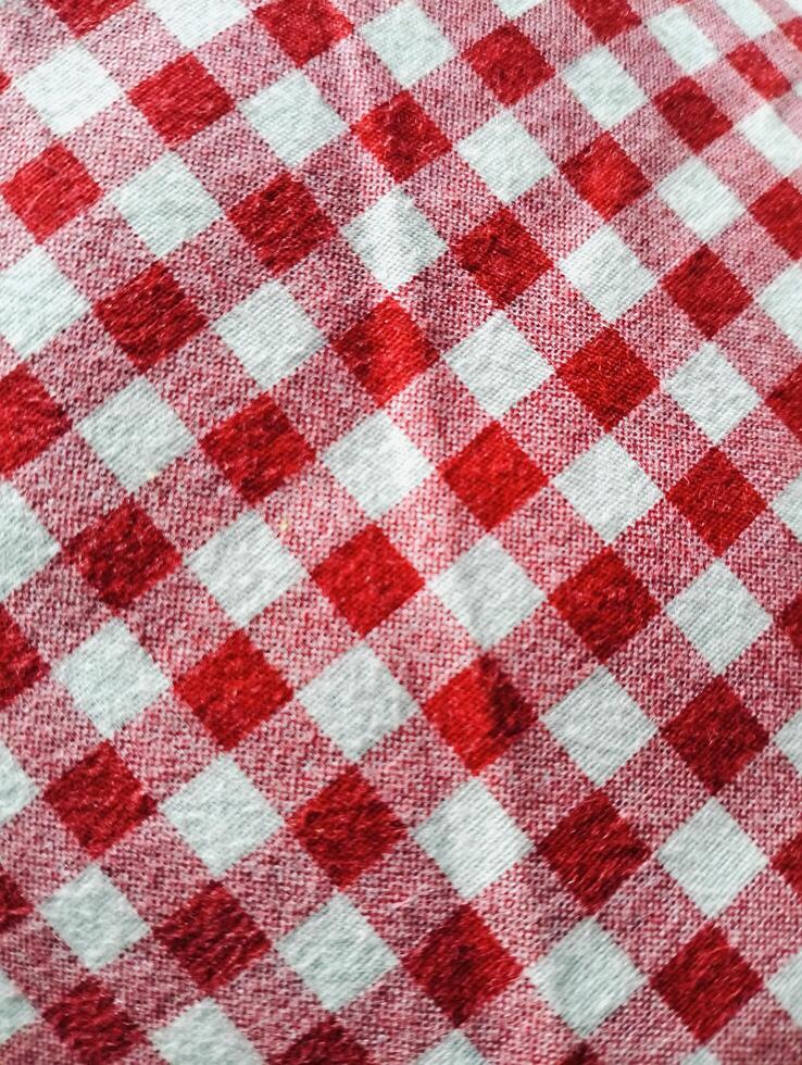 Red and white checkered tablecloth. Top view table cloth texture background. Red gingham pattern fabric. Picnic blanket texture. Red table cloth for Italian food menu. Square pattern. photo