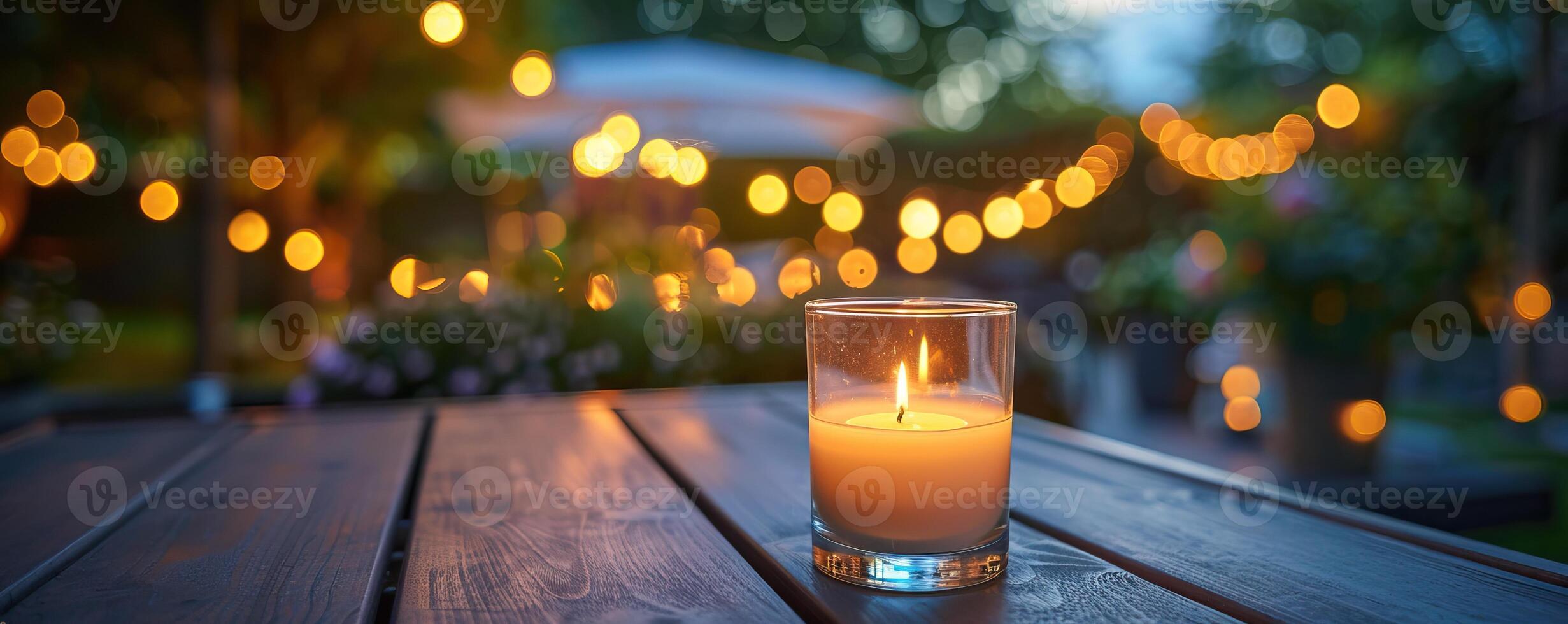 Warm and cozy outdoor evening scene with a lit candle on a wooden table, surrounded by glowing string lights, creating a serene and intimate atmosphere. photo