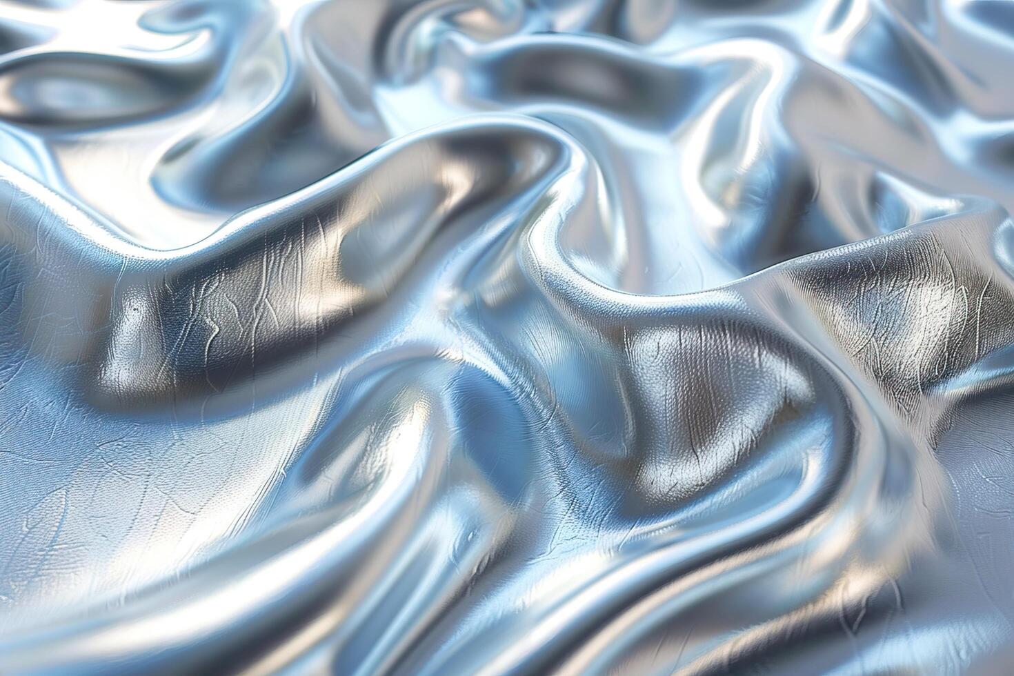 Close-up of smooth, shimmering silver fabric with intricate folds and waves creating an elegant and luxurious texture. photo