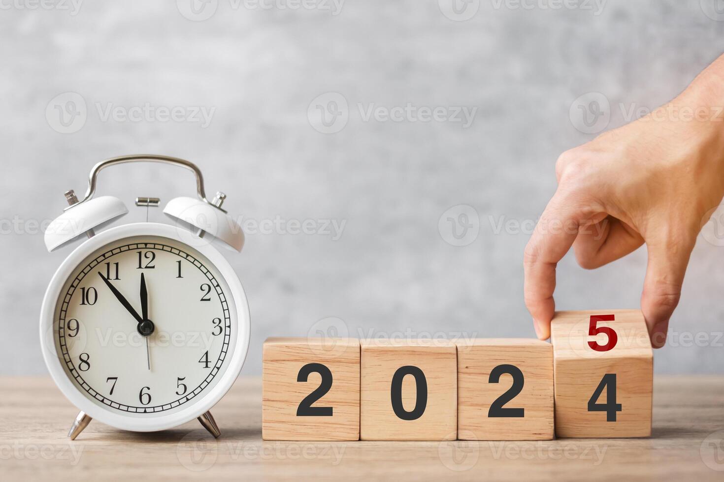 Happy New Year with vintage alarm clock and hand flipping 2024 change to 2025 block. Christmas, New Start, Resolution, countdown, Goals, Plan, Action and Motivation Concept photo