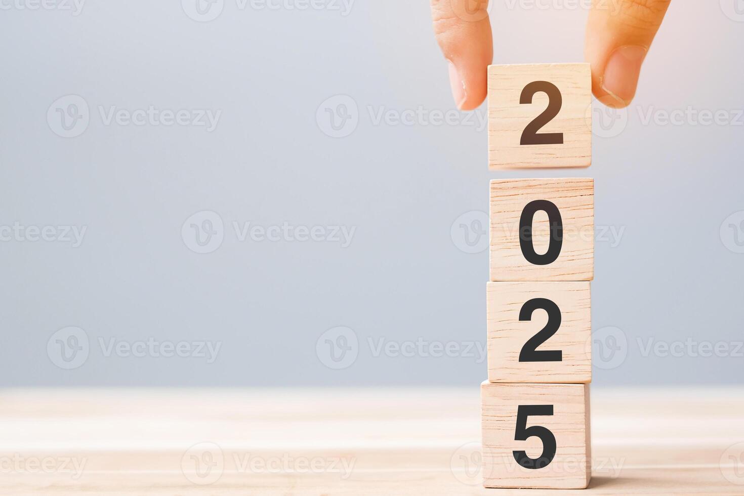 hand holding wooden cube block with 2025 text on table background. Resolution, plan, review, goal, start and New Year holiday concepts photo