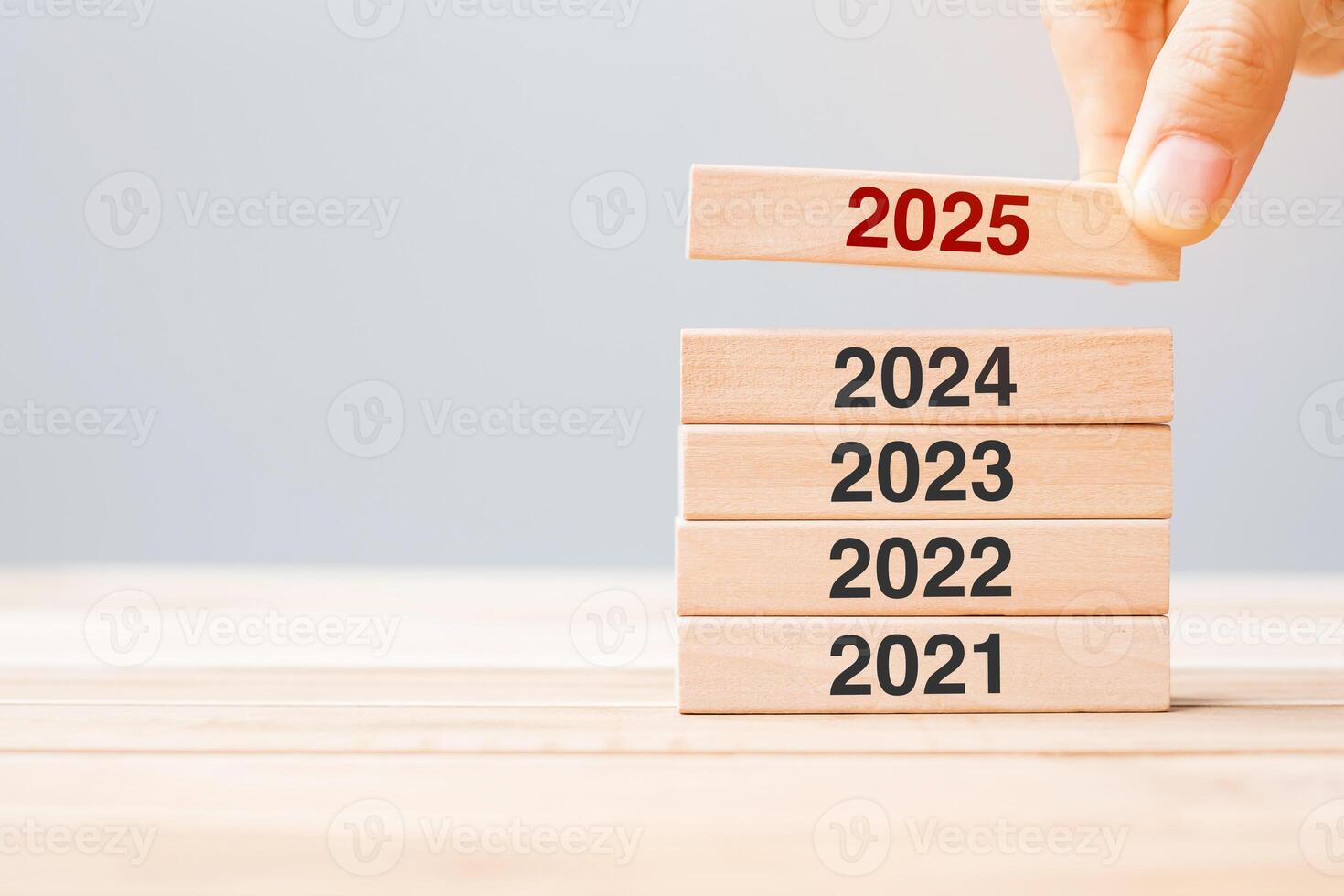 2025 block over 2024 and 2023 wooden building on table background. Business planning, Risk Management, Resolution, strategy, solution, goal, New Year New You and happy holiday concepts photo
