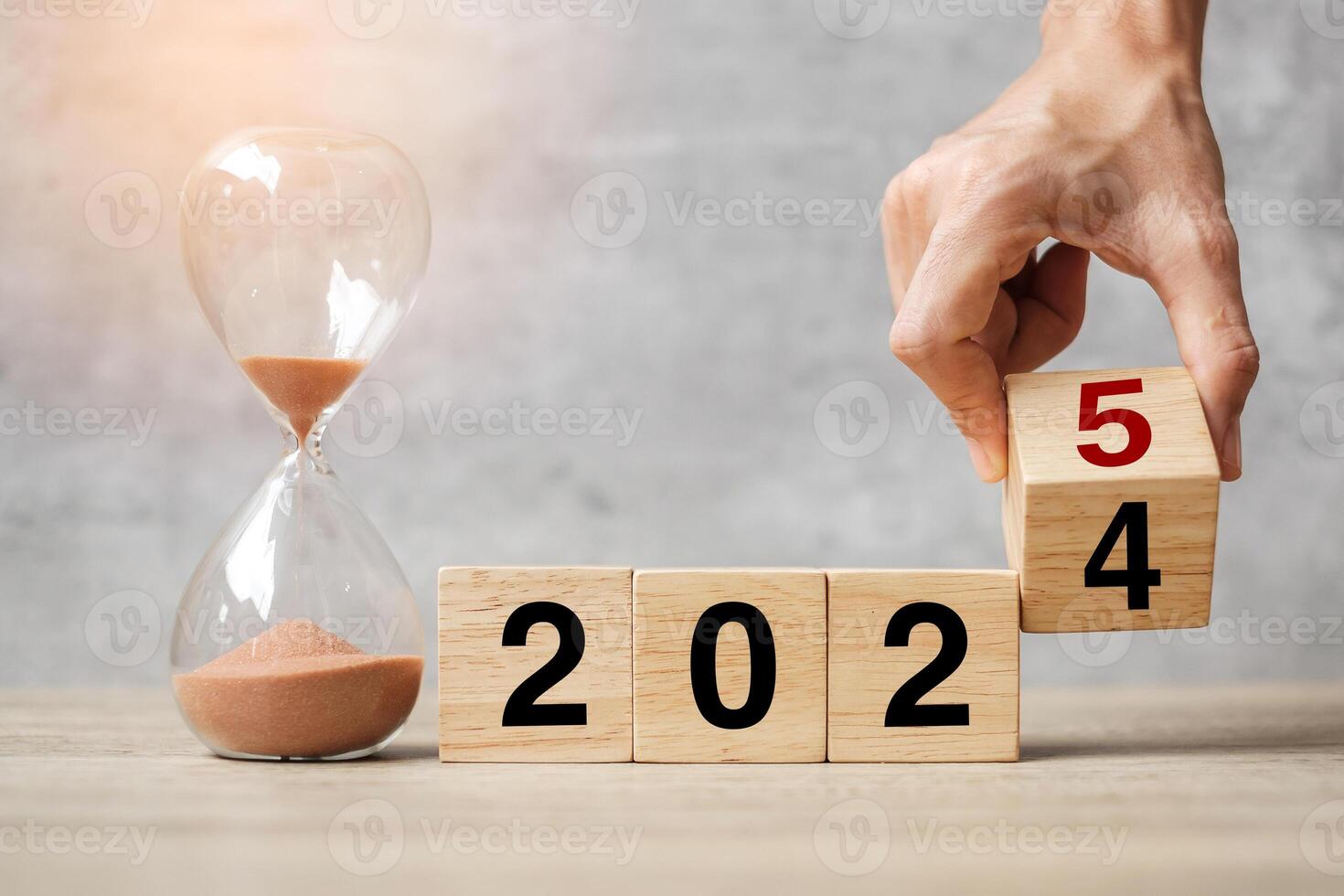 hand flipping block 2024 to 2025 text with hourglass on table. Resolution, time, plan, goal, motivation, reboot, countdown and New Year holiday concepts photo