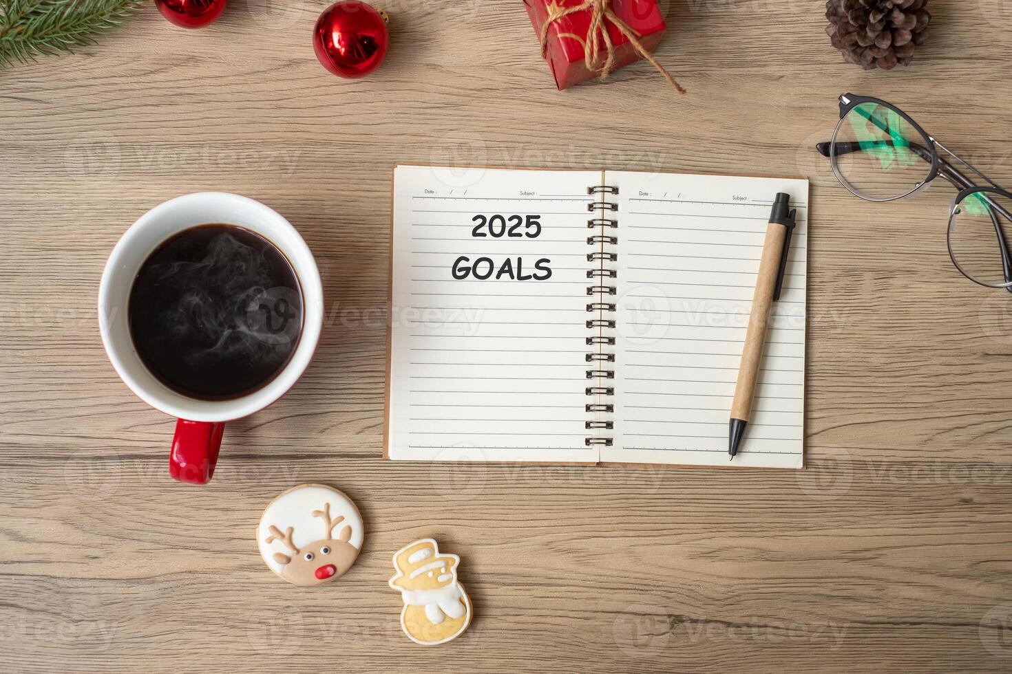 2025 GOAL with notebook, black coffee cup, Christmas cookies and pen on wood table. Xmas, Happy New Year, Resolution, To do list, Strategy and Plan concept photo