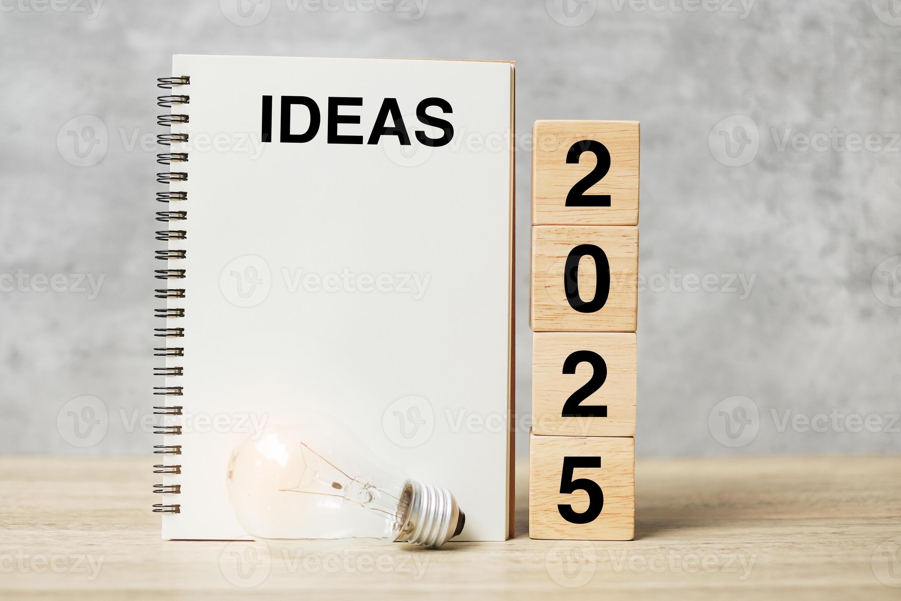 2025 text wood cube blocks and IDEAS word with lightbulb on table. New