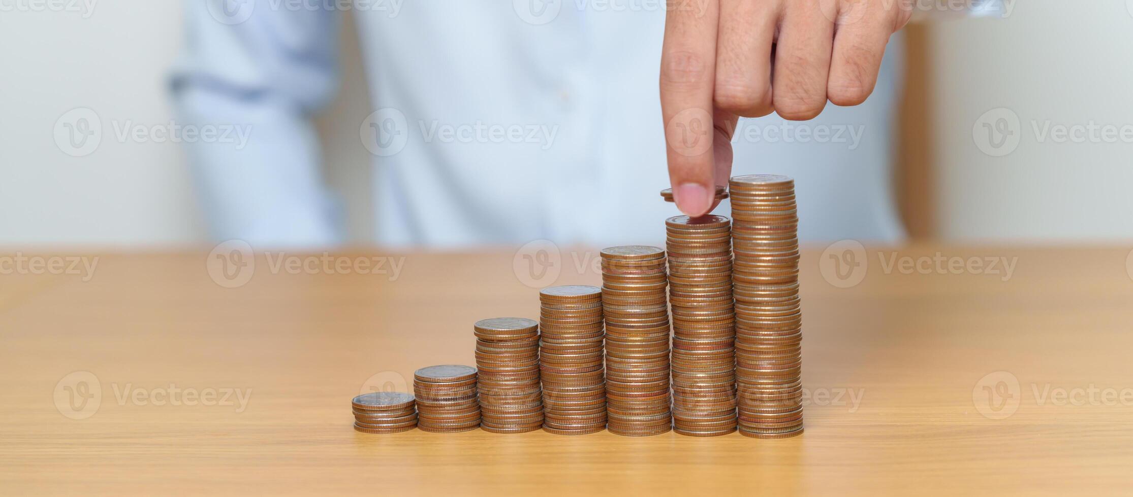 Money Saving for Future Plan, Retirement fund, Pension, Investment, Wealth Business and Financial concepts. hand putting coin into stack on table, Money counting and stack arrangement for deposit photo