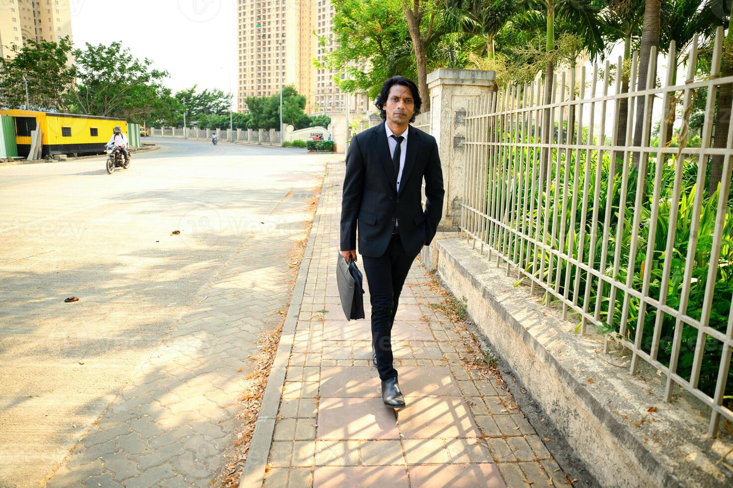 Businessman walking on sidewalk in urban area photo