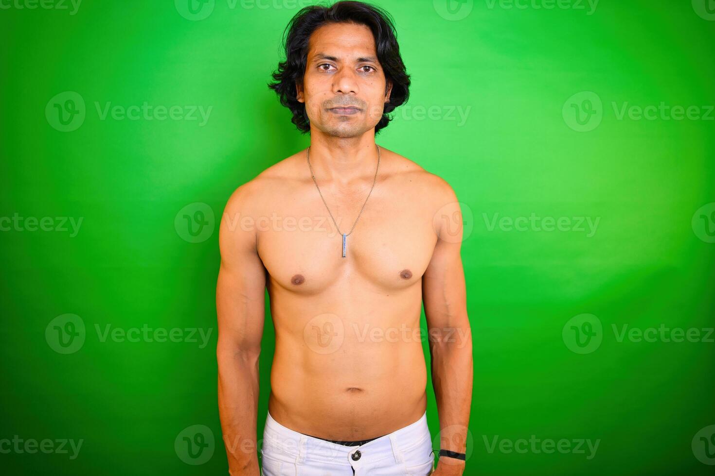 Shirtless man standing on green background photo