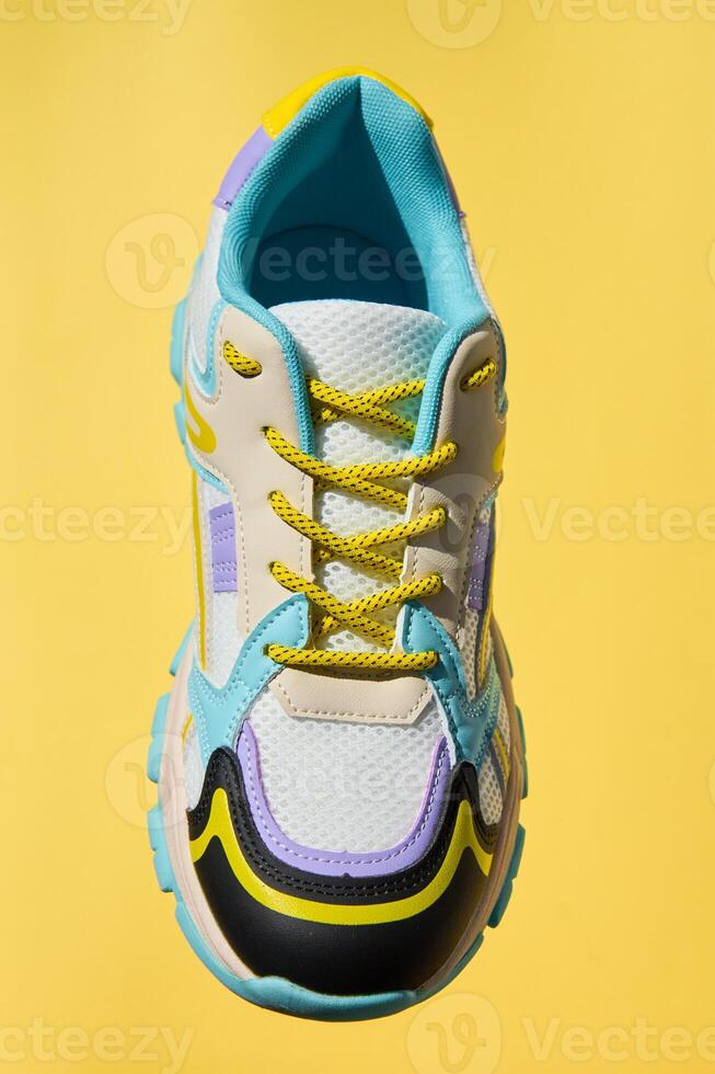 Stylish colorful shoe isolated on yellow background photo
