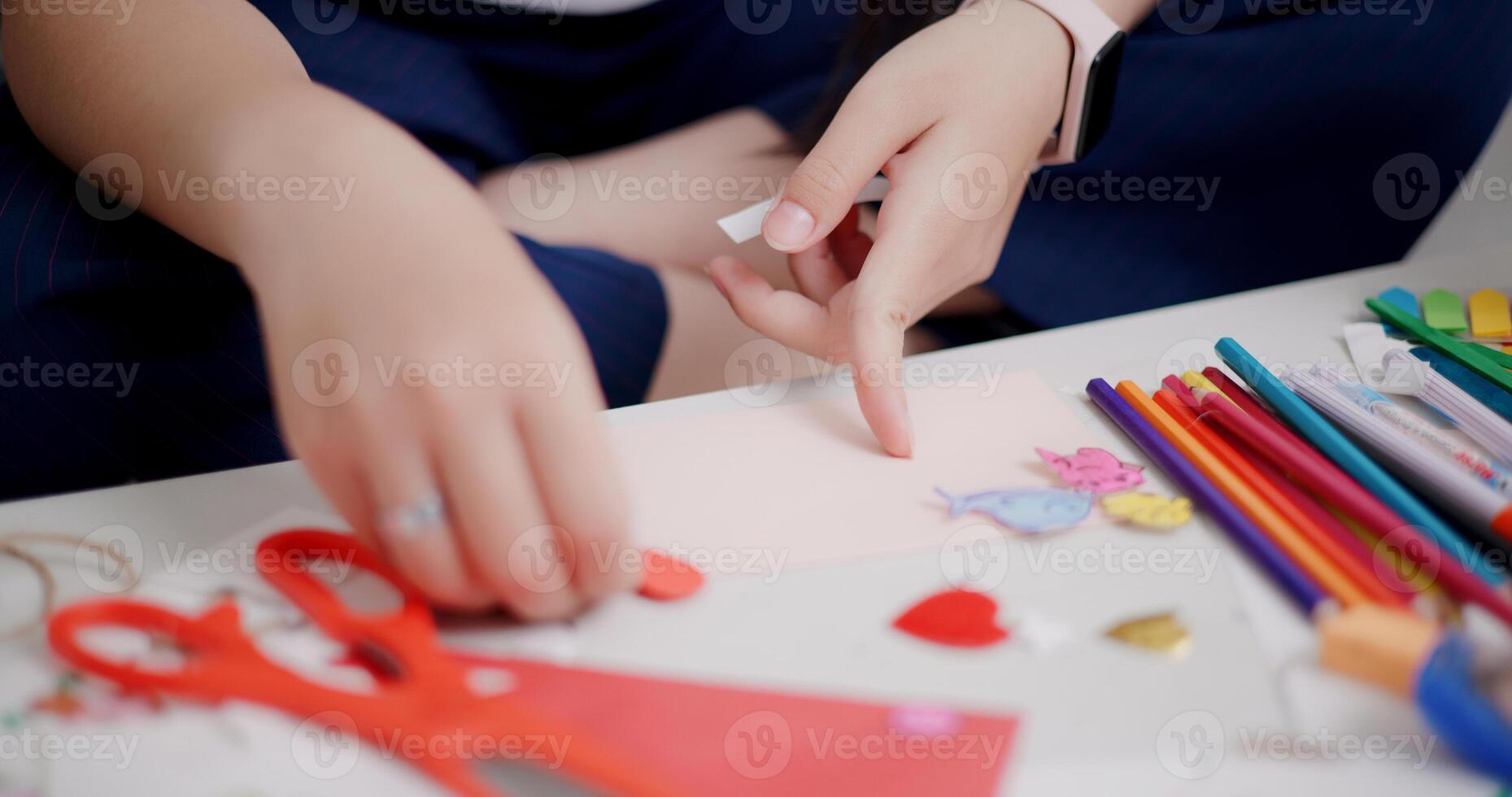 Selective focus, Hands of Young Asian woman sitting on sofa decorating a greeting card in the living room, Holiday hobbies, crafts, DIY cards photo