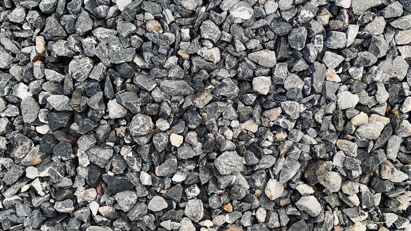 Crushed grey stone on the ground texture background, Crushed rock close up, Crushed stone road building material gravel texture, Garden gravel background stone landscaping photo