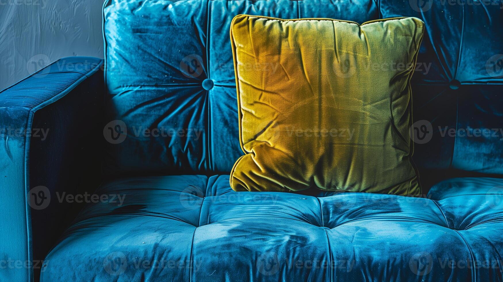 A blue velvet couch with a green cushion photo