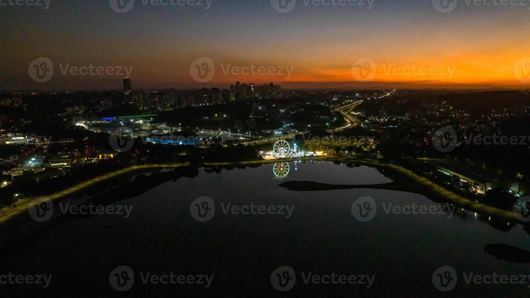 Curitiba in Parana, Brazil. Aerial View. Wonderful sunset with views of buildings and Tangua Park. Lake with reflection. photo