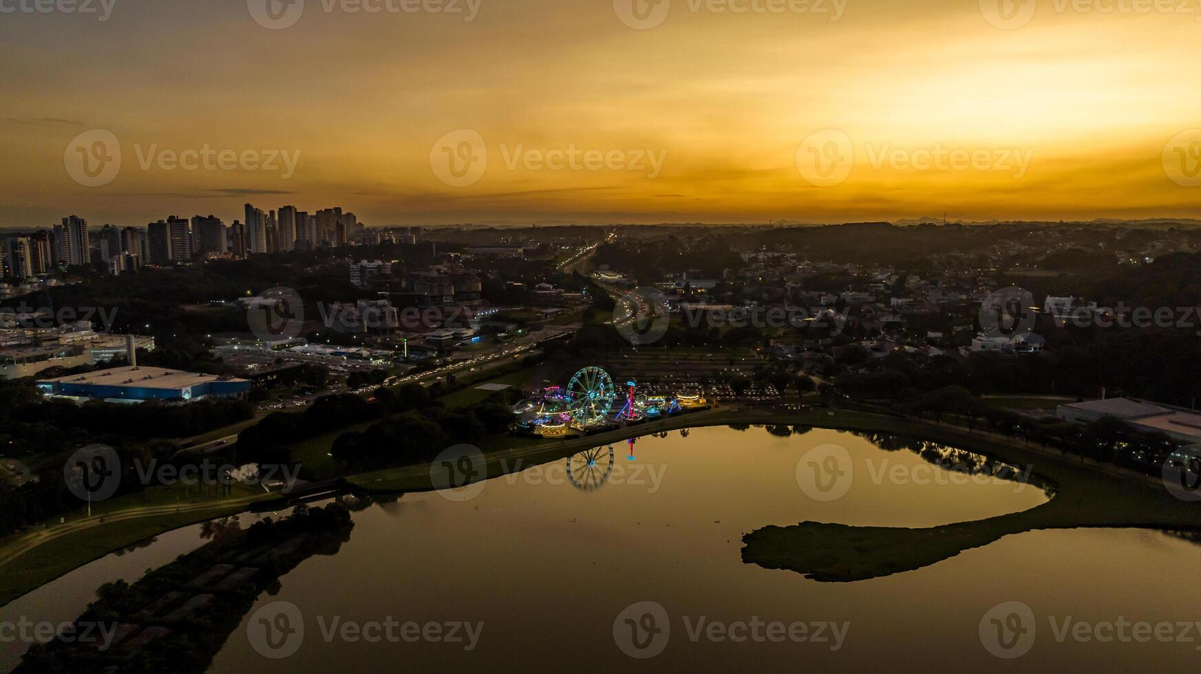 Curitiba in Parana, Brazil. Aerial View. Wonderful sunset with views of buildings and Tangua Park. Lake with reflection. photo