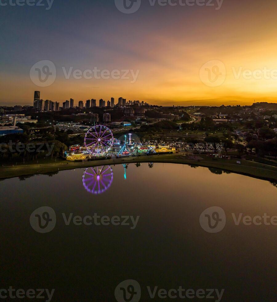 Curitiba in Parana, Brazil. Aerial View. Wonderful sunset with views of buildings and Tangua Park. Lake with reflection. photo