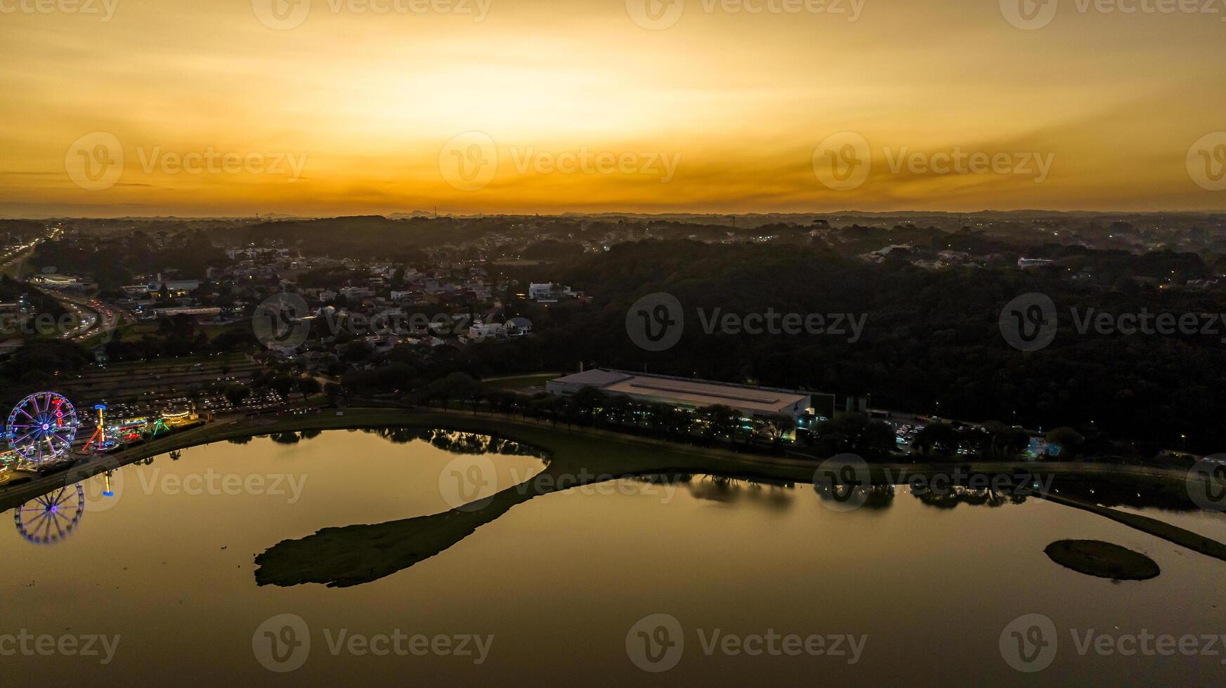 Curitiba in Parana, Brazil. Aerial View. Wonderful sunset with views of buildings and Tangua Park. Lake with reflection. photo