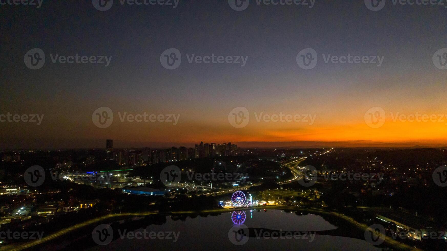 Curitiba in Parana, Brazil. Aerial View. Wonderful sunset with views of buildings and Tangua Park. Lake with reflection. photo