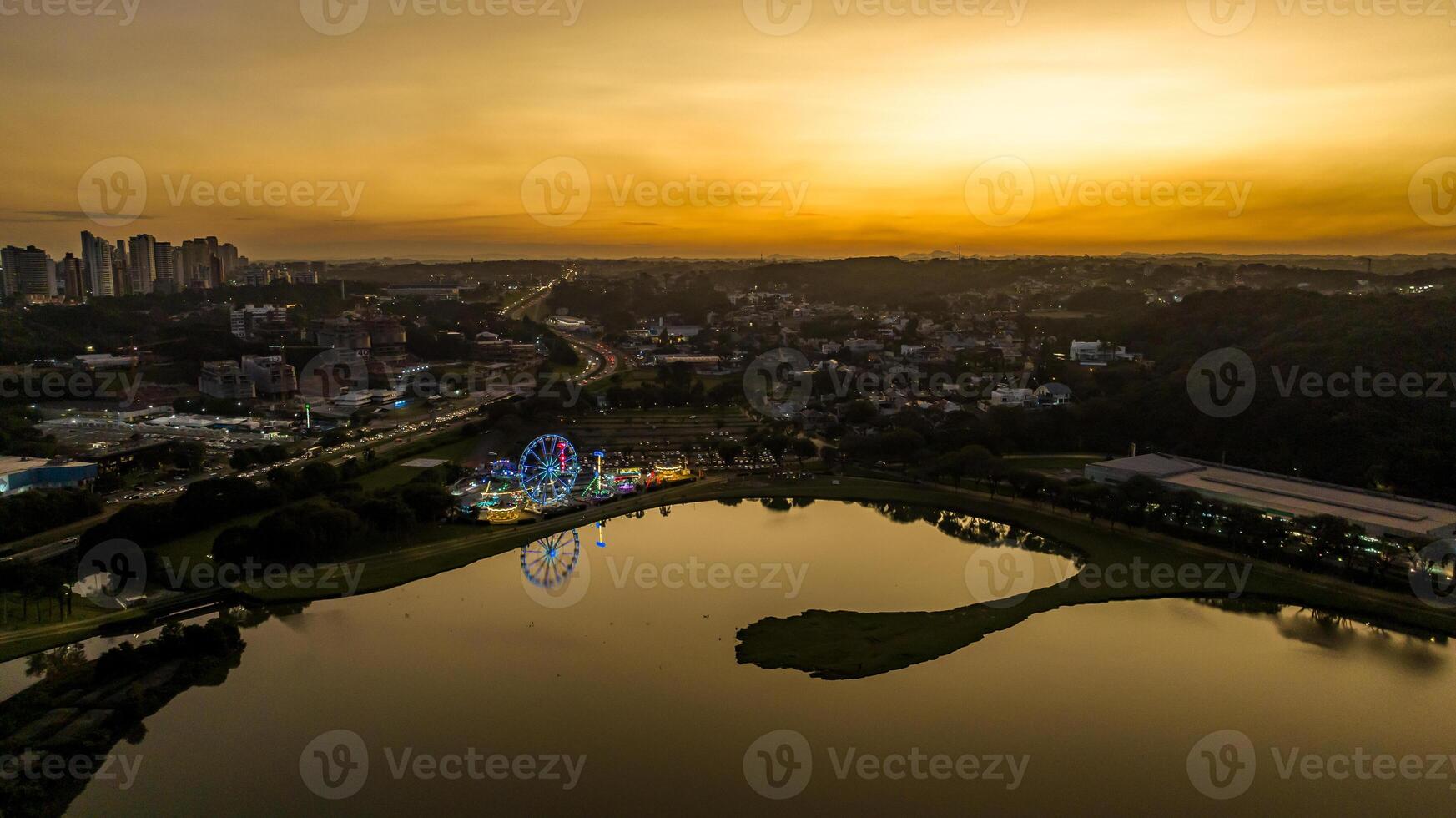 Curitiba in Parana, Brazil. Aerial View. Wonderful sunset with views of buildings and Tangua Park. Lake with reflection. photo