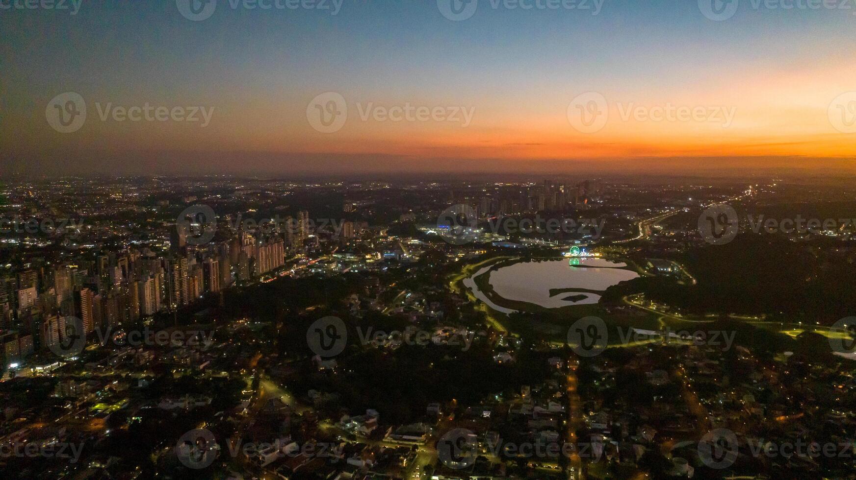 Curitiba in Parana, Brazil. Aerial View. Wonderful sunset with views of buildings and Tangua Park. Lake with reflection. photo