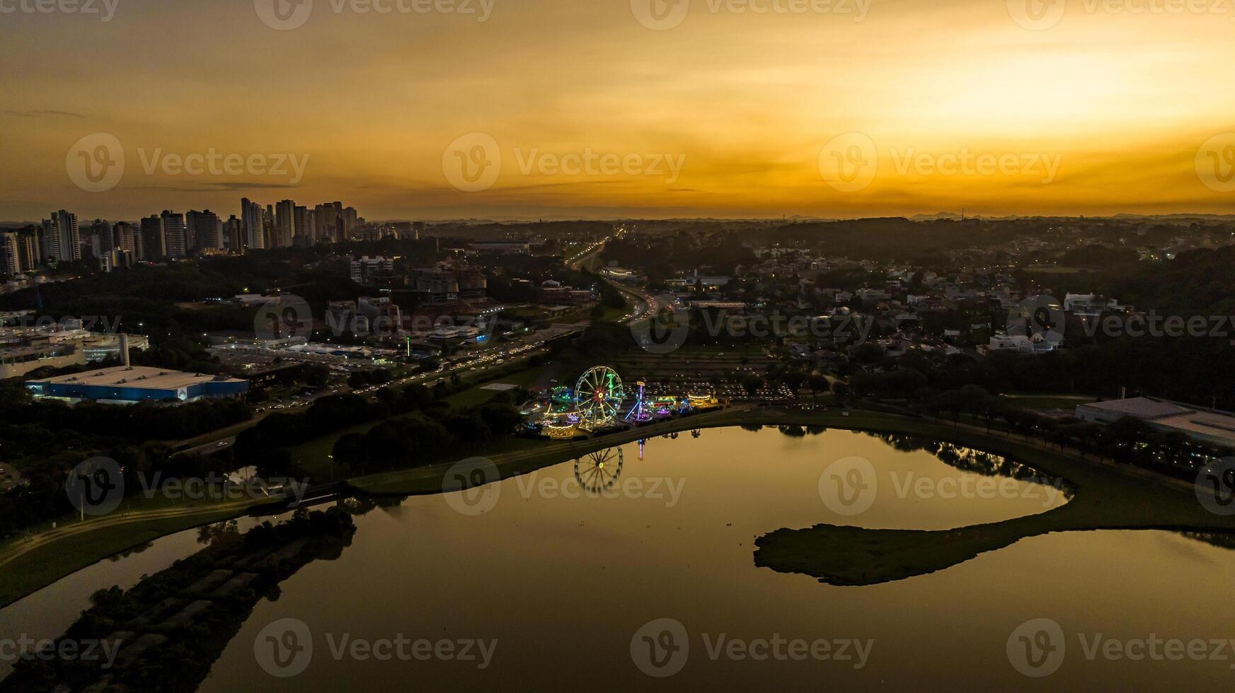Curitiba in Parana, Brazil. Aerial View. Wonderful sunset with views of buildings and Tangua Park. Lake with reflection. photo