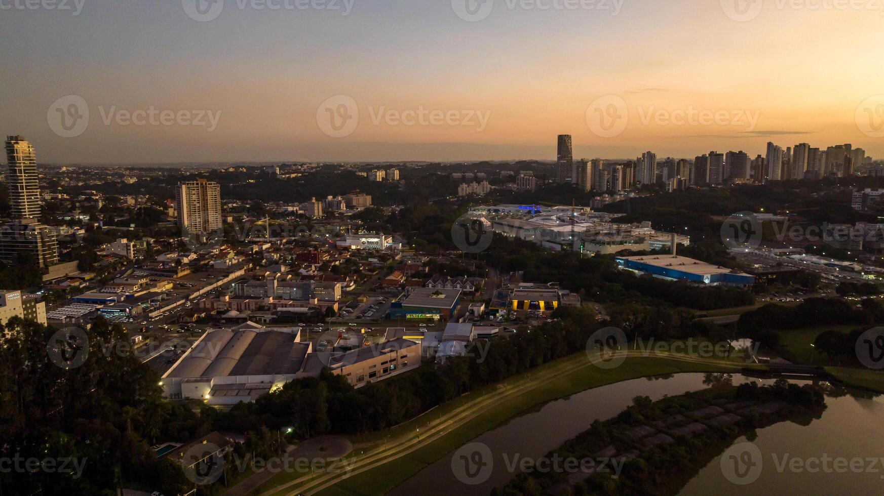 Curitiba in Parana, Brazil. Aerial View. Wonderful sunset with views of buildings and Tangua Park. Lake with reflection. photo