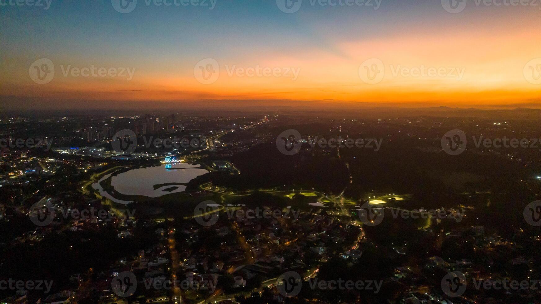 Curitiba in Parana, Brazil. Aerial View. Wonderful sunset with views of buildings and Tangua Park. Lake with reflection. photo