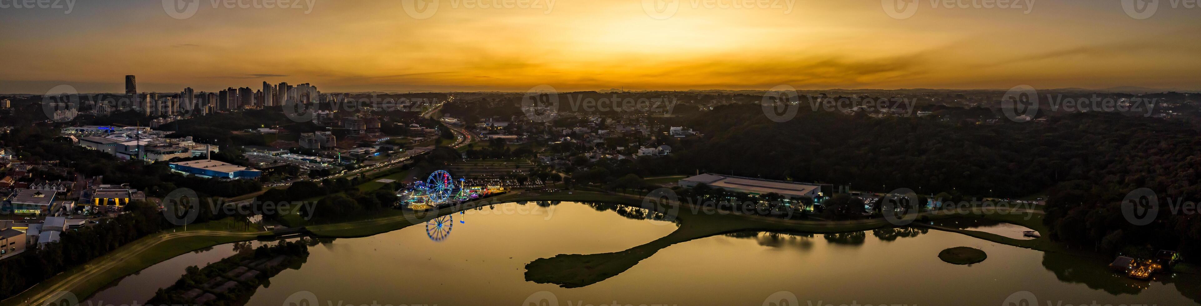 Curitiba in Parana, Brazil. Aerial View. Wonderful sunset with views of buildings and Tangua Park. Lake with reflection. photo