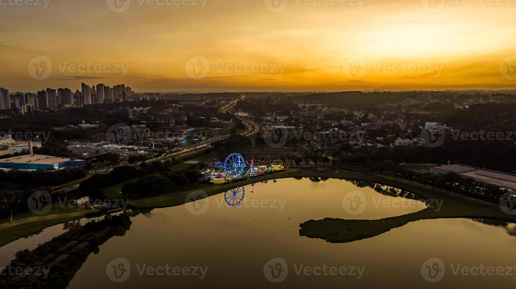 Curitiba in Parana, Brazil. Aerial View. Wonderful sunset with views of buildings and Tangua Park. Lake with reflection. photo