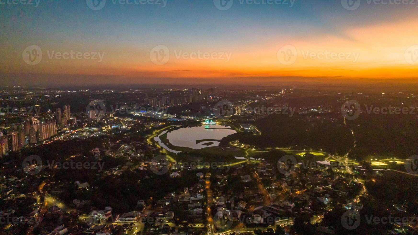 Curitiba in Parana, Brazil. Aerial View. Wonderful sunset with views of buildings and Tangua Park. Lake with reflection. photo