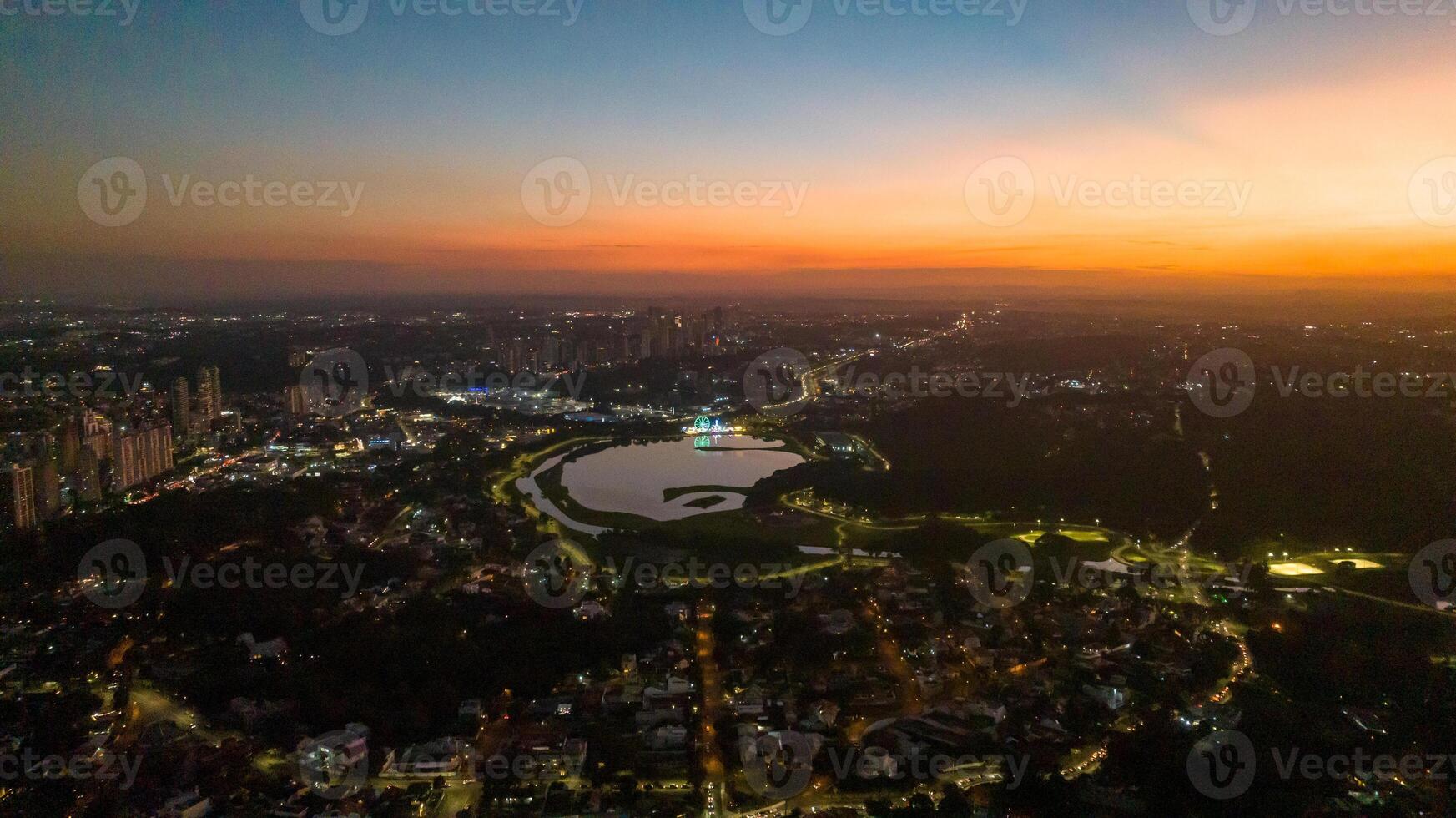 Curitiba in Parana, Brazil. Aerial View. Wonderful sunset with views of buildings and Tangua Park. Lake with reflection. photo