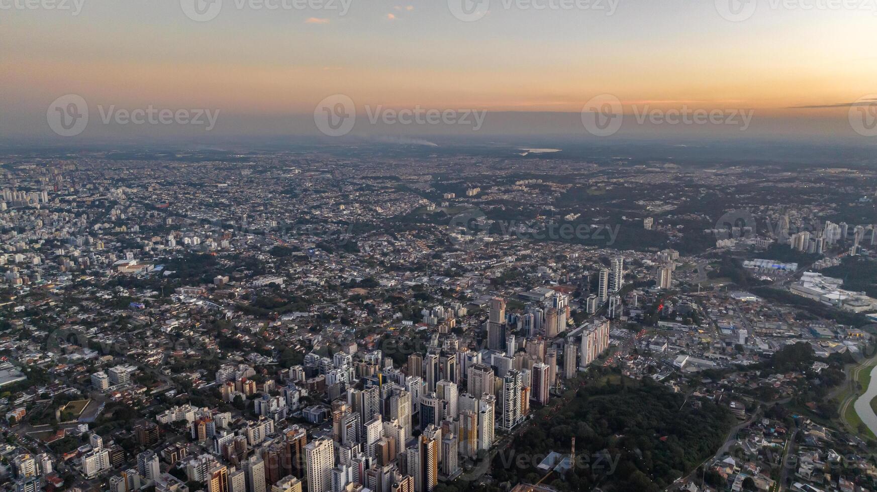 Curitiba in Parana, Brazil. Aerial View. Wonderful sunset with views of buildings and Tangua Park. Lake with reflection. photo
