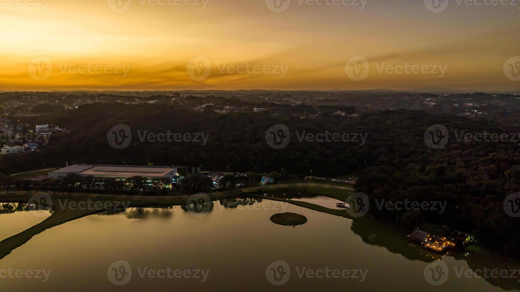 Curitiba in Parana, Brazil. Aerial View. Wonderful sunset with views of buildings and Tangua Park. Lake with reflection. photo