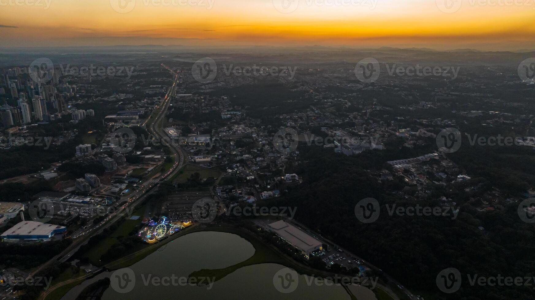 Curitiba in Parana, Brazil. Aerial View. Wonderful sunset with views of buildings and Tangua Park. Lake with reflection. photo