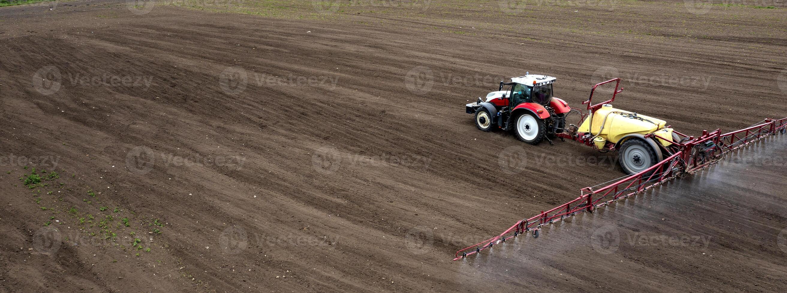 Banner view of field and tractor spraying grain photo