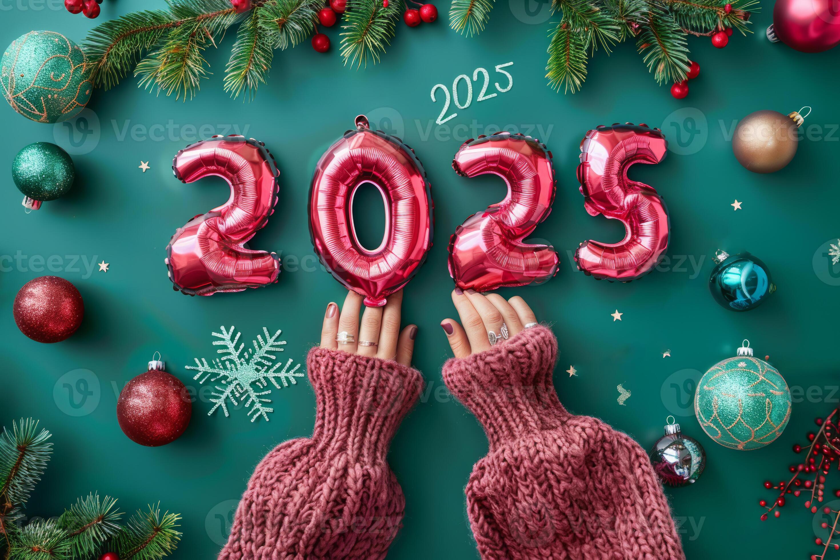 Person Holding Red 2025 Balloons On Green Background With Christmas Person Holding Red 2025 Balloons On Green Background With Christmas Ornaments Photo