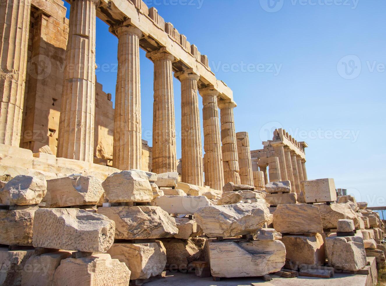 Ancient Parthenon Temple on top of the Acropolis Athens, Greece at sunny day with a blue sky. The landmark of Athens. Parthenon is the temple of for dedication to the goddess Athena. photo