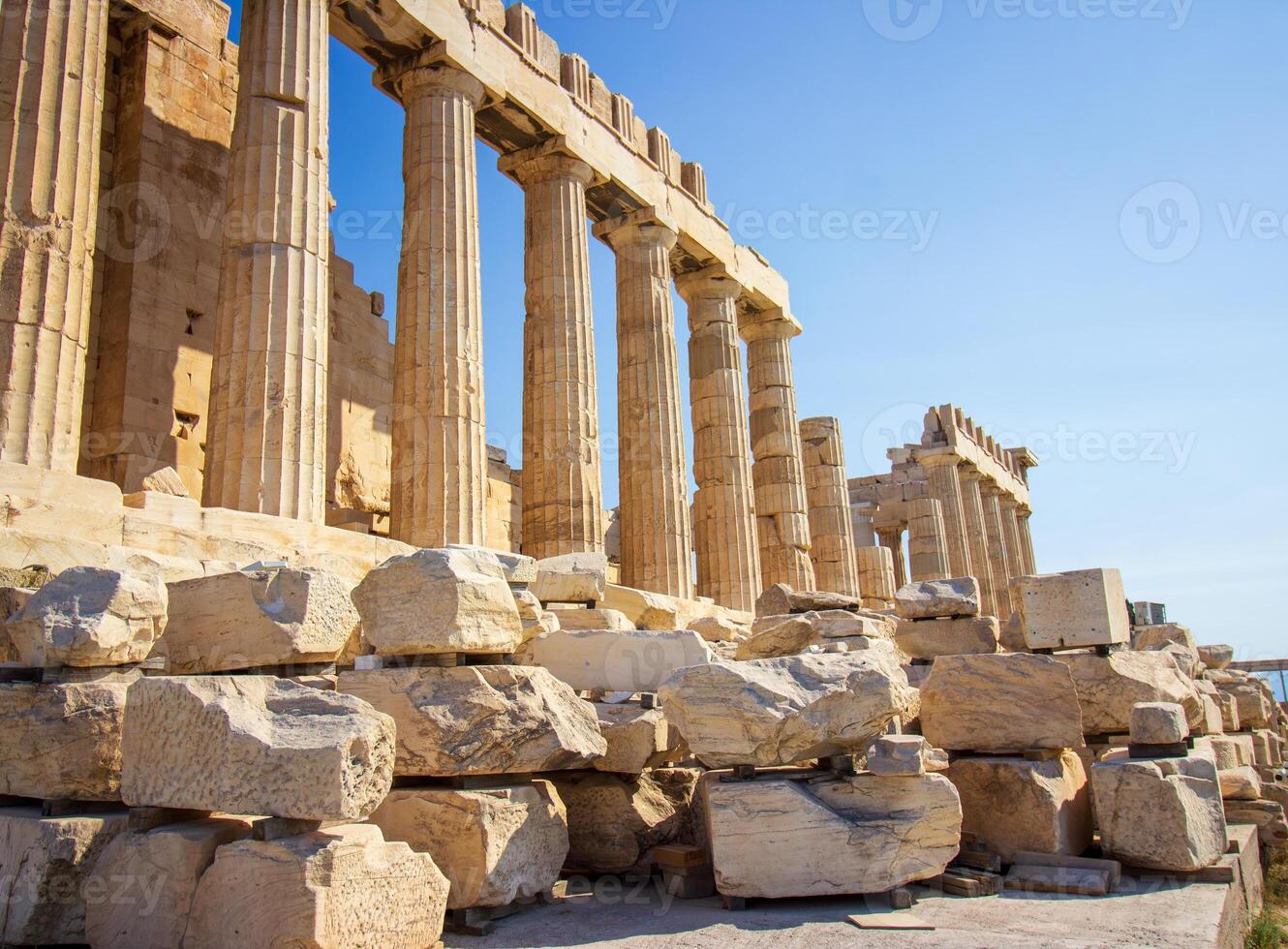 Ancient Parthenon Temple on top of the Acropolis Athens, Greece at sunny day with a blue sky. The landmark of Athens. Parthenon is the temple of for dedication to the goddess Athena. photo