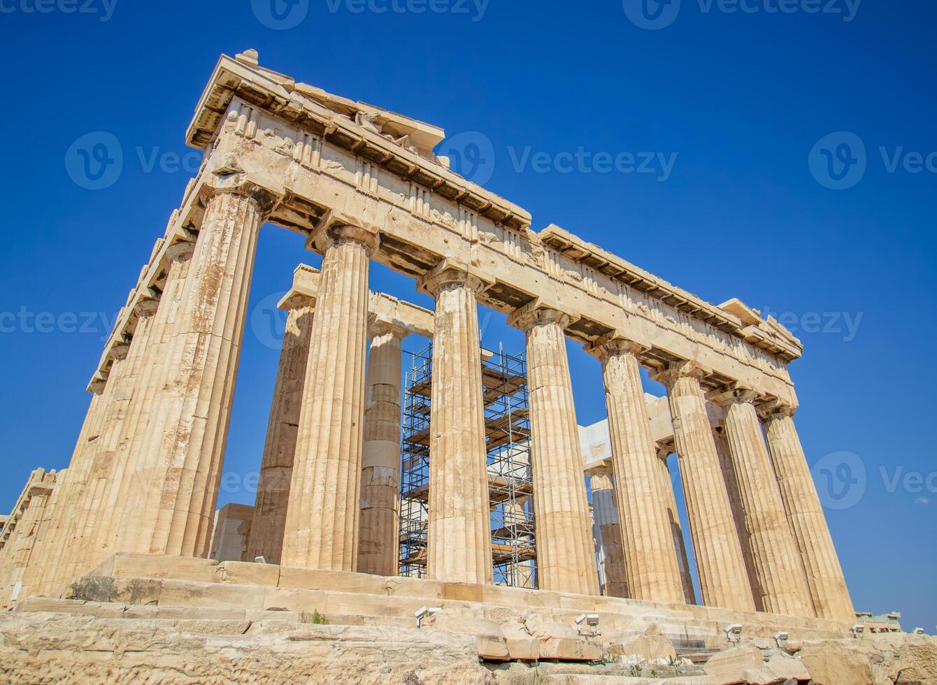 Ancient Parthenon Temple on top of the Acropolis Athens, Greece at sunny day with a blue sky. The landmark of Athens. Parthenon is the temple of for dedication to the goddess Athena. photo
