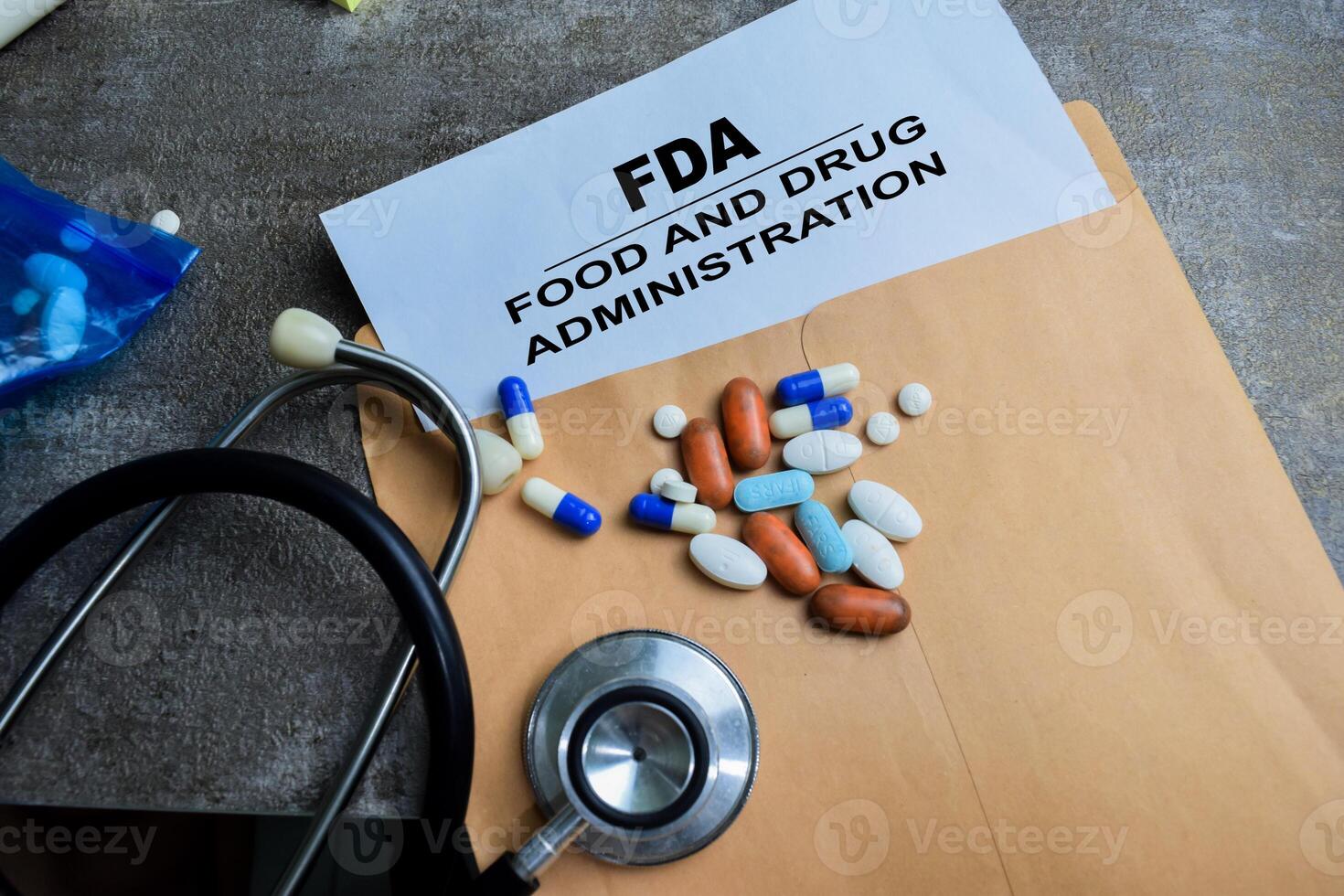 Red Handle Rubber Stamper and FDA - Food And Drug Administration text above brown envelope isolated on wooden background photo